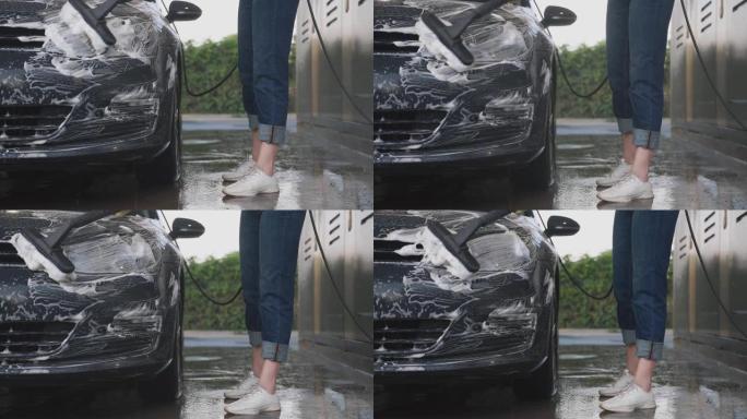 穿着统一清洁车的女人用刷子。洗车服务。