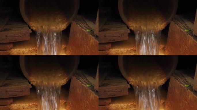 铁过量的水从大管里流出。管壁生锈。