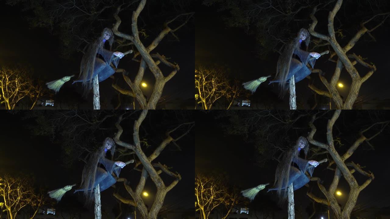 晚上在公园的稻草扫帚上的可怕女巫雕塑没有花和干燥的树的一侧