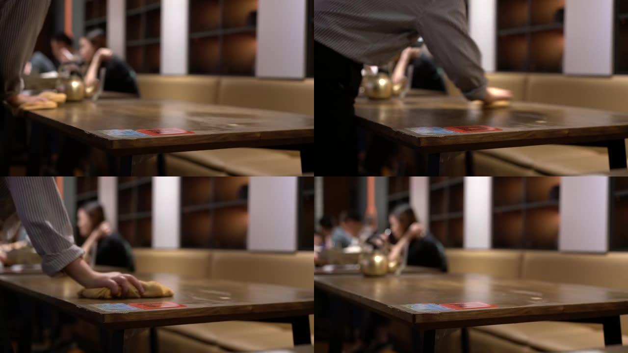 客人离开后，餐厅的服务员用抹布擦拭桌子