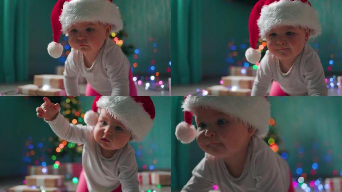 戴着圣诞帽的可爱的蹒跚学步的女孩，爬过节日的灯光。慢动作。圣诞节假期的概念