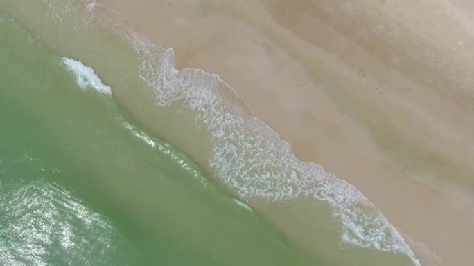 在沙质海岸线上破碎的turquiose海浪的俯视图