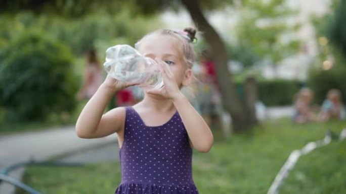 小女孩喝水大塑料瓶夏日公园