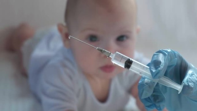 儿科医生给新生婴儿接种疫苗。疫苗，婴儿儿童疫苗接种软焦点注射器在护士的手和模糊的婴儿背景上的白色。戴