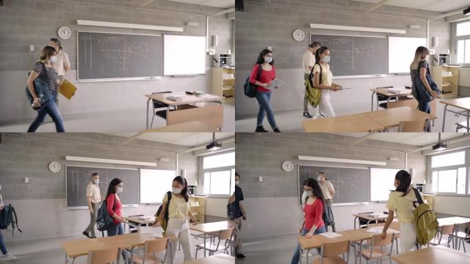老师欢迎戴着防护口罩进入教室的学生。教育新常态，针对新型冠状病毒肺炎冠状病毒采取安全措施。
