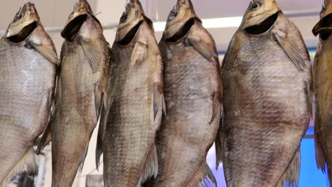 鱼干在鱼海鲜传统街头市场的陈列柜上。挪威传统Stockfish户外干燥。一排干腌鱼鲷鱼挂在市场上。