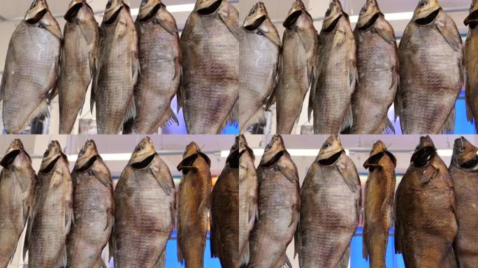 鱼干在鱼海鲜传统街头市场的陈列柜上。挪威传统Stockfish户外干燥。一排干腌鱼鲷鱼挂在市场上。