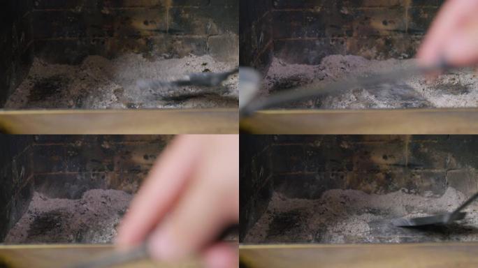 一个人用旧的铁簸箕搅拌，并在木柴燃烧后从木柴中收集灰烬和煤渣，并将其关闭。使用后清洁壁炉