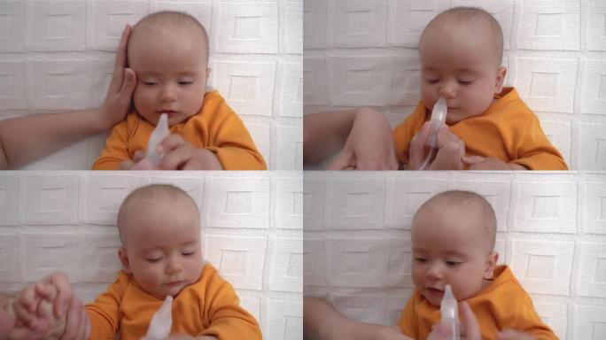 父母使用鼻吸器清除婴儿鼻子上的粘液。孩子哭了，反复无常。顶视图