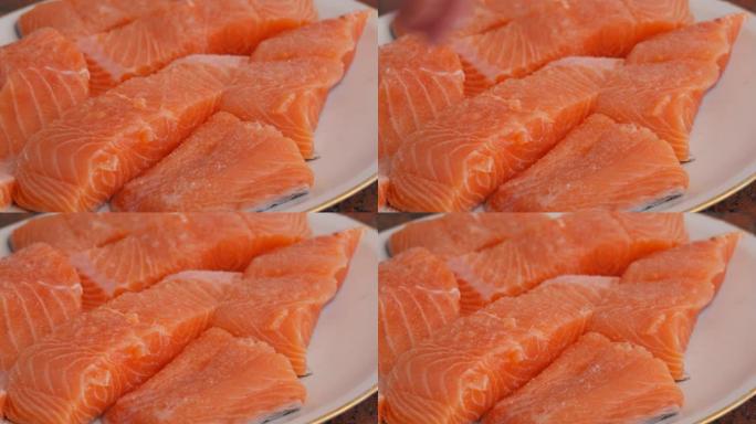 将巨大的红鱼鲑鱼切成薄片，在盘子上腌制