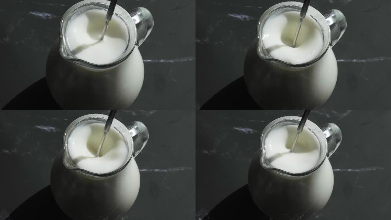 用起泡剂在杯子里打牛奶。牛奶手动搅拌器。用起泡剂制作泡沫牛奶。为咖啡准备牛奶。一步一步