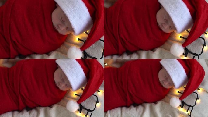 顶视图肖像生命的第一天新生儿可爱有趣的睡在圣诞老人帽子包裹在白色花环背景的红色尿布。圣诞快乐，新年快