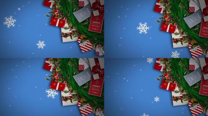 雪花落在蓝色背景下的圣诞花环装饰和礼物上