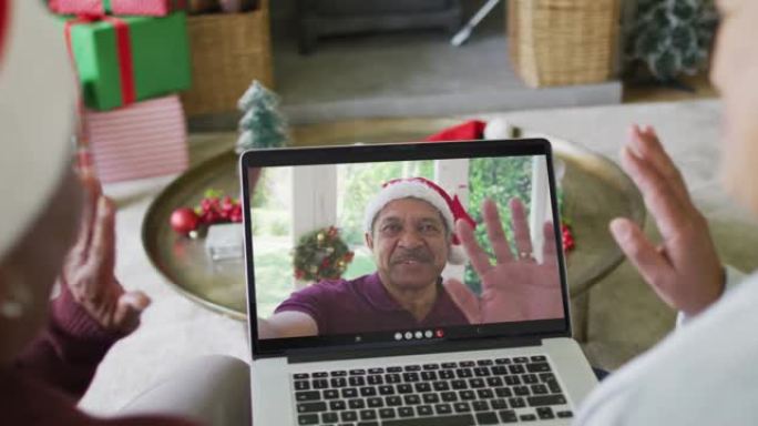 资深女性朋友使用笔记本电脑进行圣诞节视频通话，屏幕上有微笑的朋友