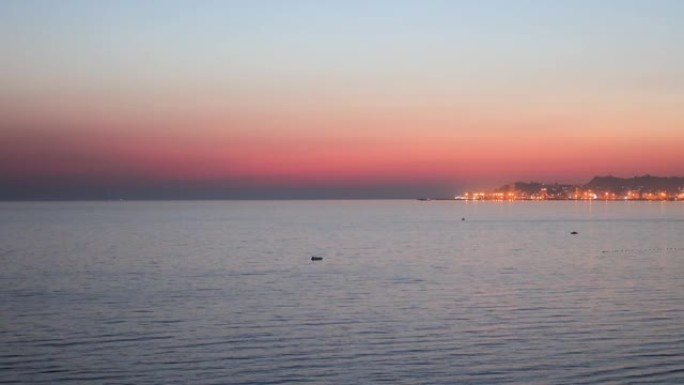 阿尔巴尼亚杜勒斯海滩的田园诗般的平静日落，背景是杜勒斯市