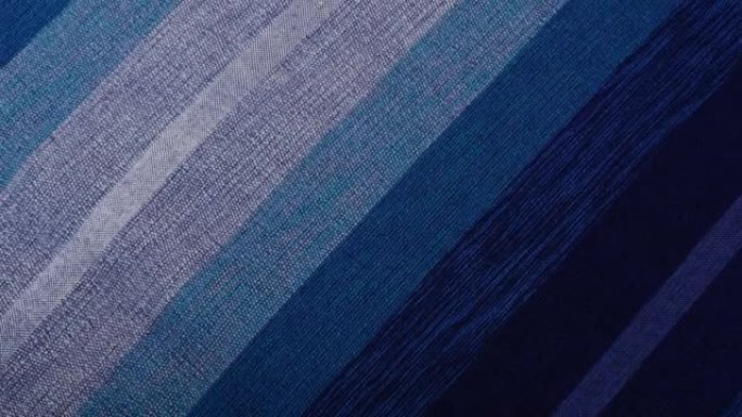 手摇传统的摩洛哥床罩，由仙人掌丝绸和羊毛制成，呈蓝色阴影。