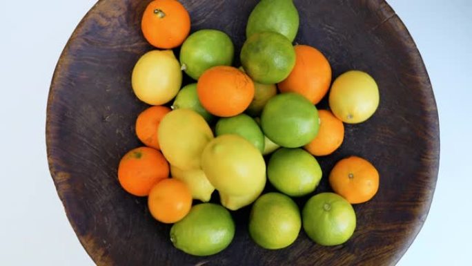 柑橘类水果，柠檬，橘子，放在古董木碗中。维生素c，健康清爽，天然有机食品生活方式背景。