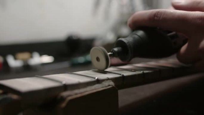 琴师在4k 60fps Prores总部乐器修理厂的吉他指板上抛光新的品格