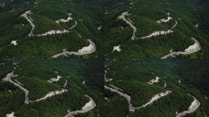 俄罗斯绿色森林山上的汽车从弯道道路上方鸟瞰图