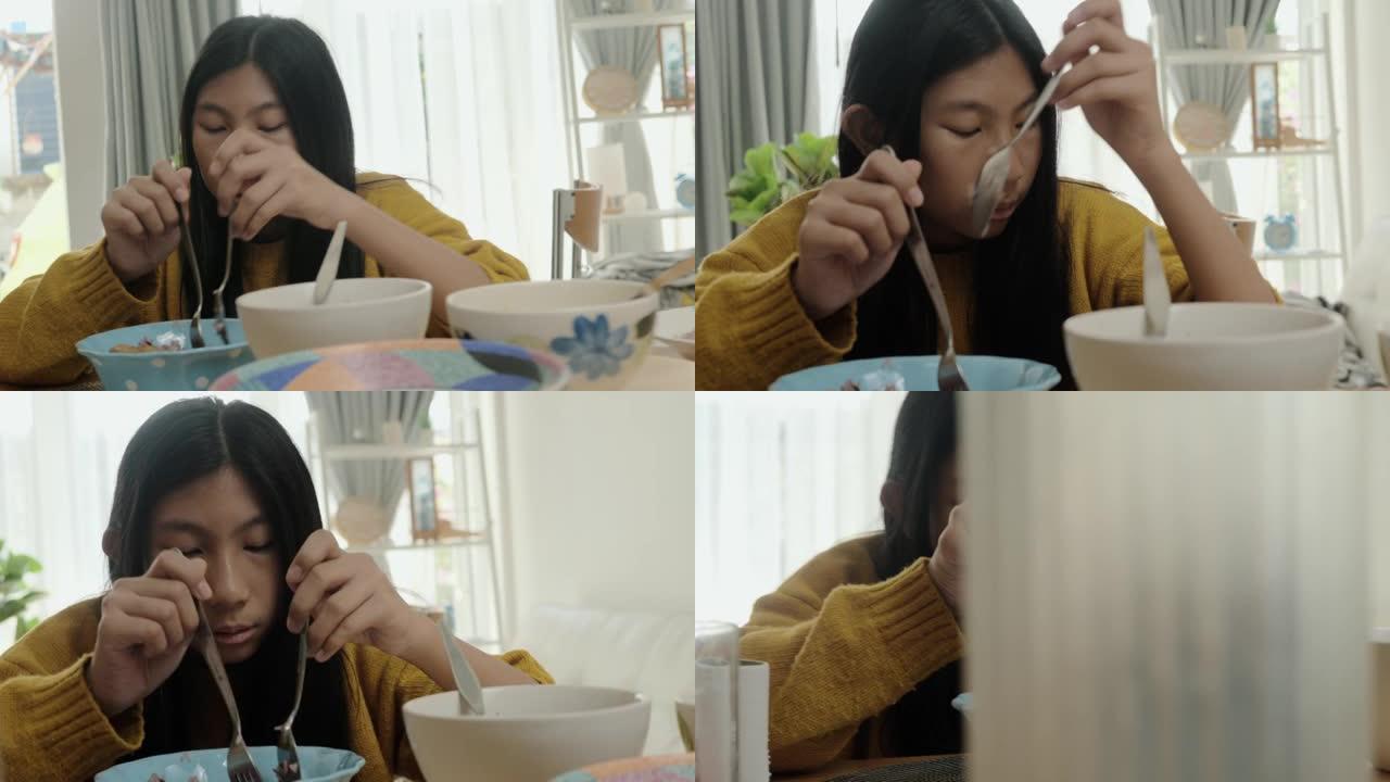 亚洲女孩穿着黄色毛衣，在家享受美食，检疫生活理念。