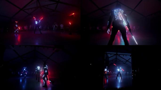 夜总会的LED表演。令人印象深刻的年轻人舞蹈在黑暗中发光二极管照明。激光表演