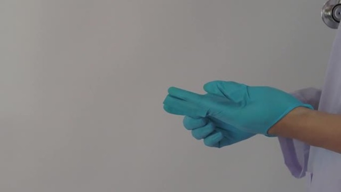 戴着手套。男医生戴蓝色橡胶丁腈手手套。医生戴上手套的镜头。孤立的白色背景复制空间。医疗保健保护冠状病
