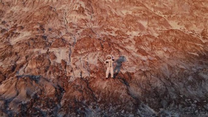 宇航员站在岩石上跳舞。阳光明媚。航空摄影