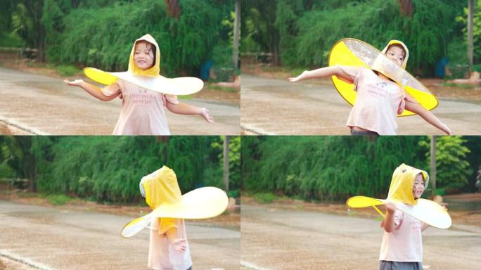 亚洲小女孩在雨中玩水。