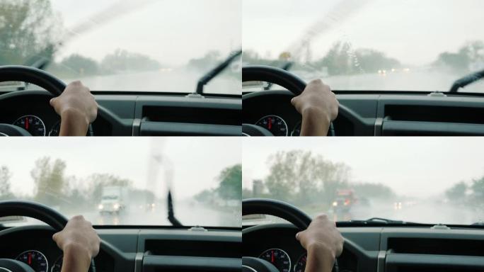 司机在大雨中驾驶汽车，透过汽车挡风玻璃观看