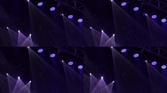 舞台上有五颜六色的聚光灯。灯从黑暗中打开。