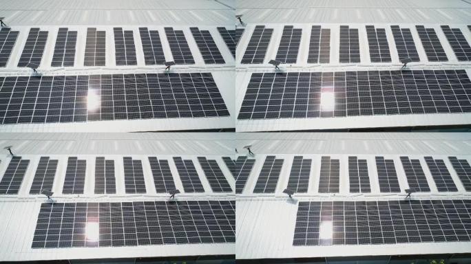 在屋顶上安装太阳能电池板的技术人员的Arial视图。