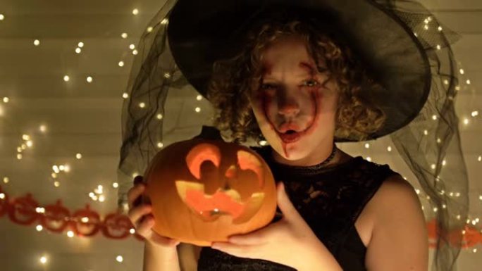 一个十几岁的女孩的肖像打扮成女巫，脸上妆容吓人。女孩手里拿着一个南瓜灯。深金色背景。万圣节