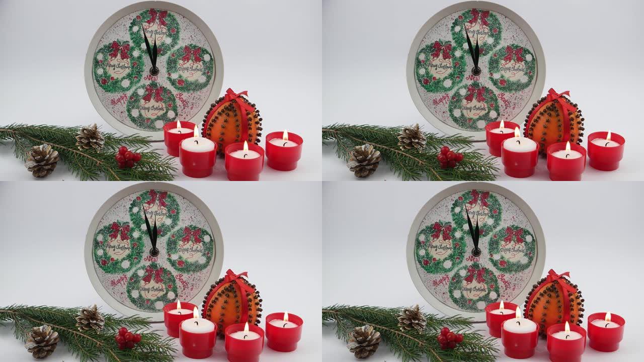 五香橙色水果pomander球，装饰圣诞节钟，燃烧的蜡烛，柑橘类水果在杉木锥和杉木树枝之间的木桌上