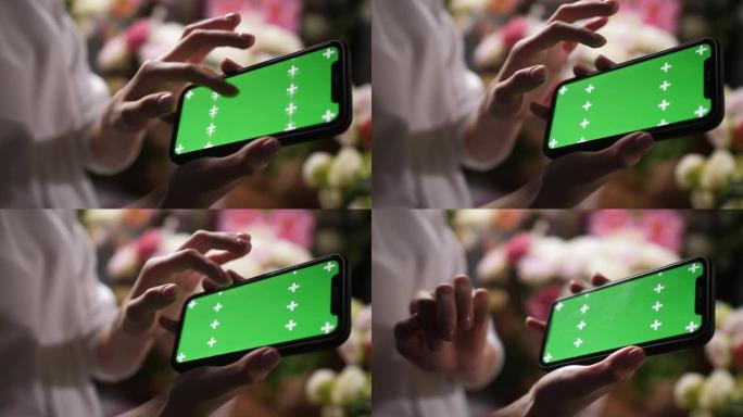 女孩手握iphone智能手机，带绿色模型色度键屏幕，用于广告