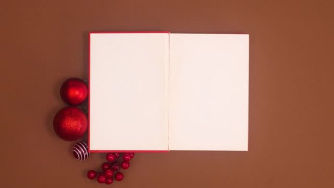 红皮书打开，圣诞节装饰品出现在书本周围。停止运动