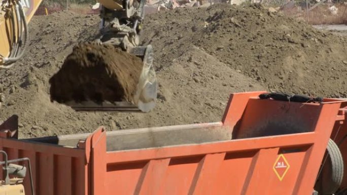 挖掘机将地面挖泥机放在卡车上