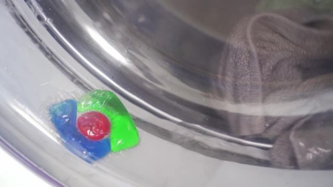 装有洗衣粉的胶囊卡在洗衣机的门上。