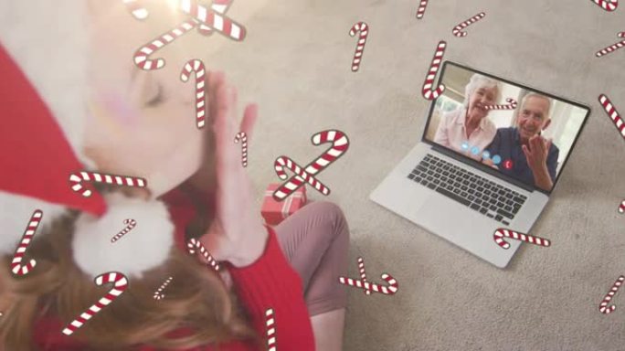 在与家人的笔记本电脑视频通话中，糖果手杖掉落在圣诞老人帽子上的白人妇女的动画