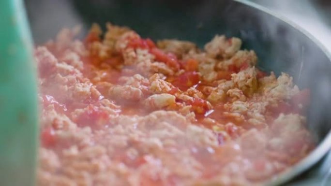 油炸肉末制作墨西哥玉米卷的过程。油炸和搅拌肉末。用硅胶刮刀搅拌鸡末。墨西哥美食