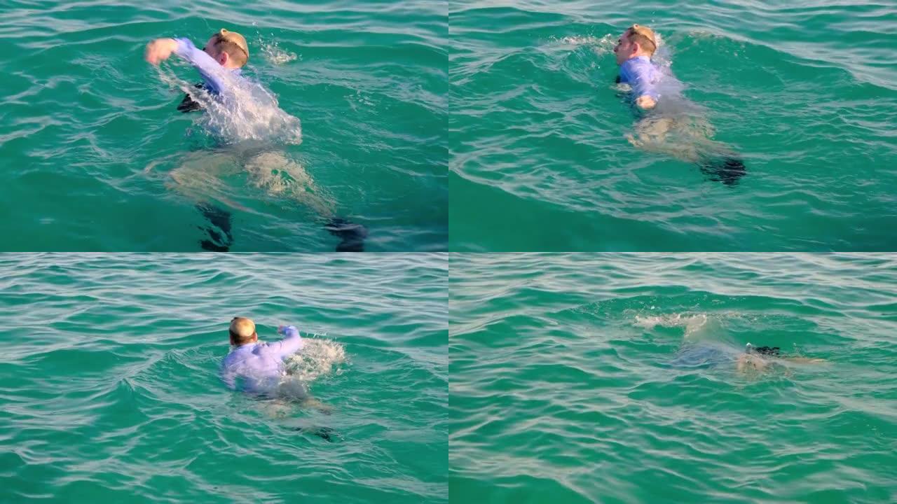 一个穿着衬衫，领带和袜子的有趣男人在阳光明媚的日子在海里游泳，然后潜入水下。慢动作，4k