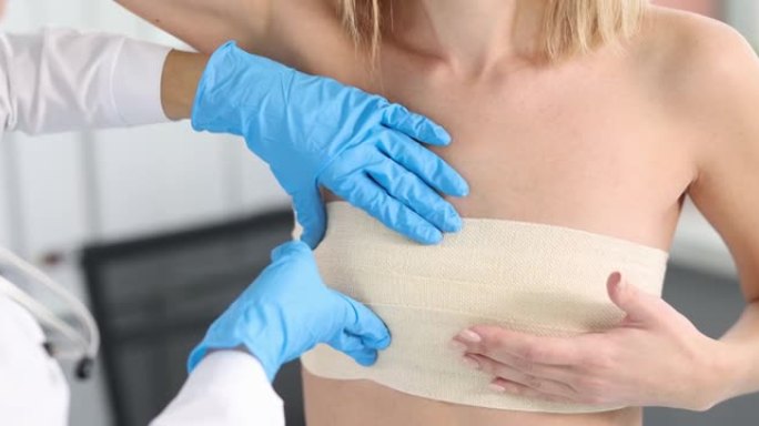 医生乳腺医生在橡胶手套触诊病人乳房与弹性绷带4k电影