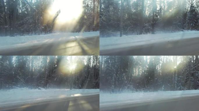 穿过美丽的冬季森林、汽车窗景和阳光的道路。高质量的全高清视频。