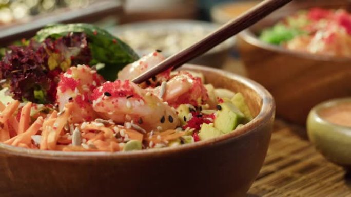吃戳碗特写，用筷子取虾。由切片蔬菜、海鲜和绿色植物制成的传统夏威夷菜肴。健康素食。亚洲素食生食