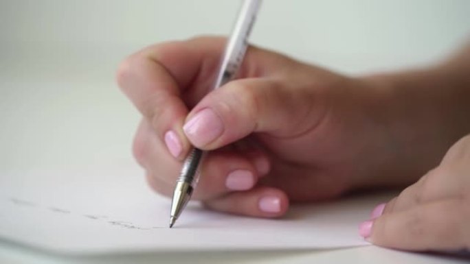年轻女子用粉红色修指甲的自信手写道