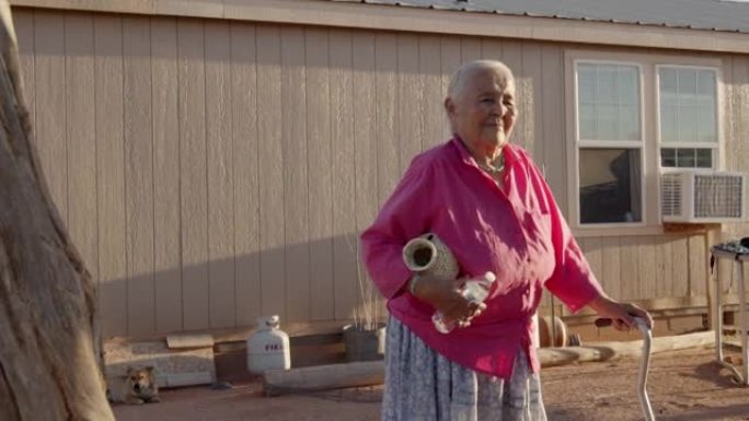 快乐，微笑的美国原住民纳瓦霍族妇女自豪地拿着她做的篮子