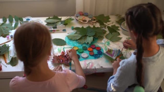 孩子们的秋季工艺。用枫叶制成的动物狐狸。儿童艺术和创意。由天然材料制成的手工艺品。女孩用颜料画画。