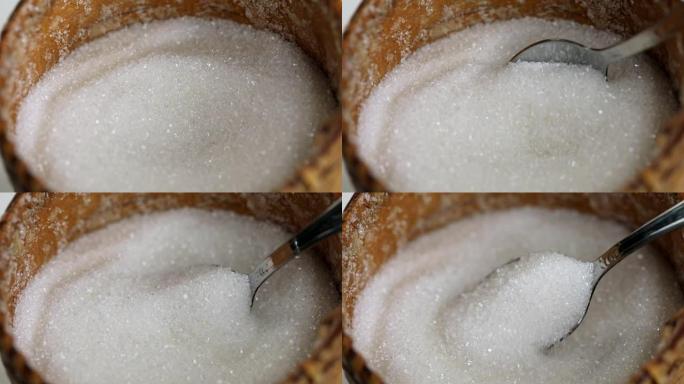 用勺子从糖碗中拿起白糖的过程特写，慢动作。不健康饮食观念，糖瘾，糖尿病