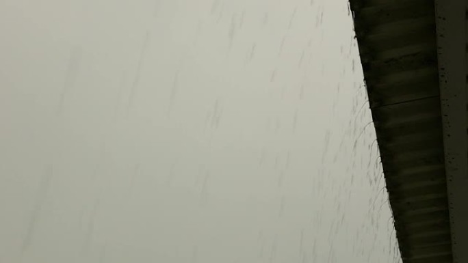 雨水从房顶迅速流下来。夏季暴雨时漏水。多云阴雨天气主题。选择性聚焦
