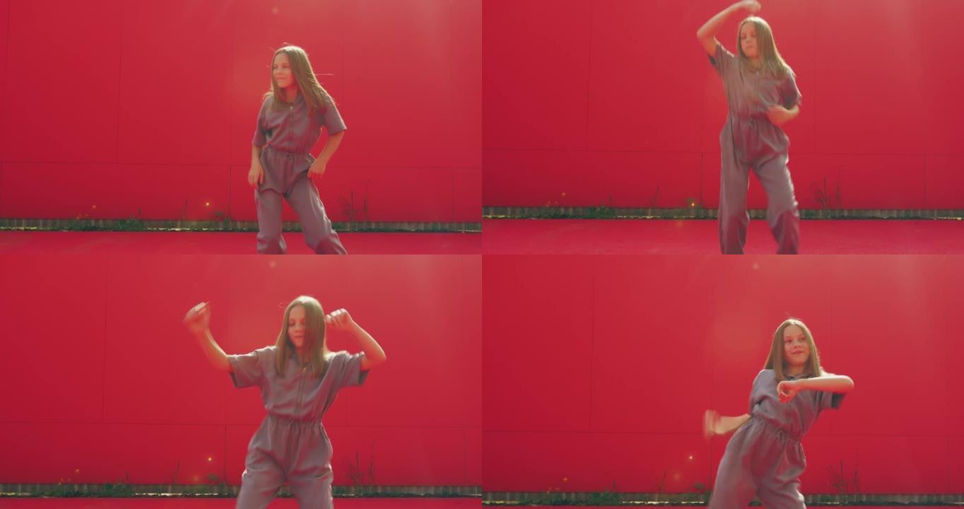 酷女孩少年在户外红墙背景上跳舞当代充满活力的表现力舞蹈。舞蹈动作，节奏