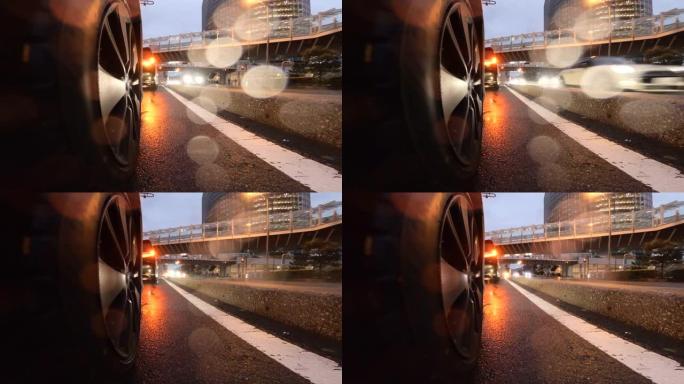 在雨夜开车穿过城市。汽车车轮的特写。在十字路口等着右转。